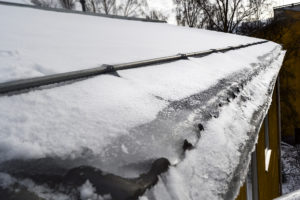 Lumenpudotus Helsingissä vaatii nopeaa työskentelytahtia. Tässä kuvassa jäätä on päässyt kertymään tiilikatolle, jossa onneksi on lumieste.