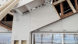 Rappauslevyn asennus vaikean muotoiseen kohteeseen. Kuvassa levyjä, puukoolausta sekä räystäs.