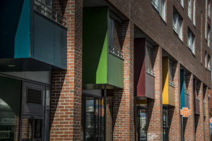 Trespa asennus parvekkeille: kuvassa värikkäitä parvekkeita kadun yläpuolella.