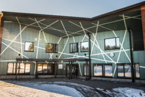 Kuvassa Fundermax asennus, Monitoimitalo Onnin monikulmainen sisäänkäynnibn julkisivu. Seinä on vihreää korkeapainelaminaattia.